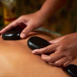 The master does back massage with special stones, spa treatments, magnets. High quality photo